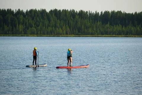 Two on Paddleboards Float on Lake in Bright Day Stock Photos