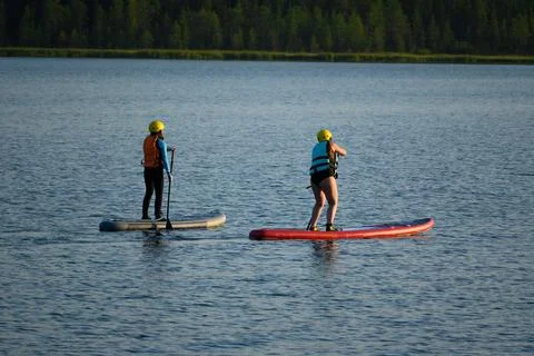 Two on Paddleboards Float on Lake in Bright Day Stock Photos