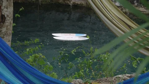 Two paddleboards gently floating on the calm, clear water of a natural sinkhole 動画素材 340346718