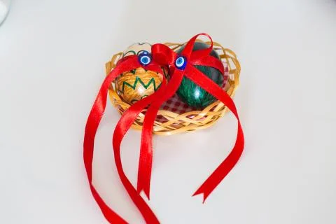 Two painted eggs with evil eye on a basket with red ribbons. Stock Photos