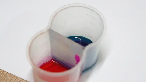 Two paints in a container. Blue and red paint. Mixing colors. Painting. Stock Footage 129043587
