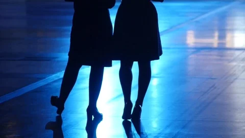 Two pair of female slender legs are on the party in blue backlight background Stock Footage 71854965