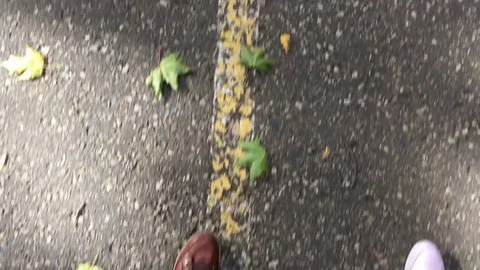 Two pair of legs walk on asphalt at autumn day. Video stock 81195865