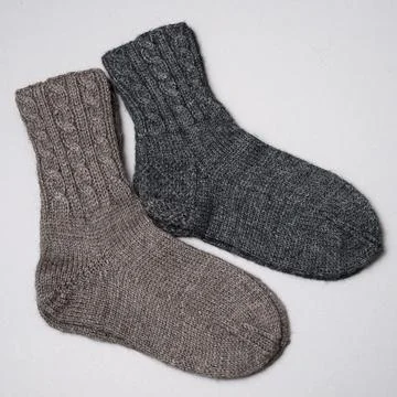 Two pair of woolen knitted socks on a neutral background Stock Photos
