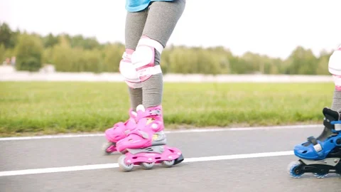 Two pairs of bright roller skates go to the stadium Stock Footage 113873265