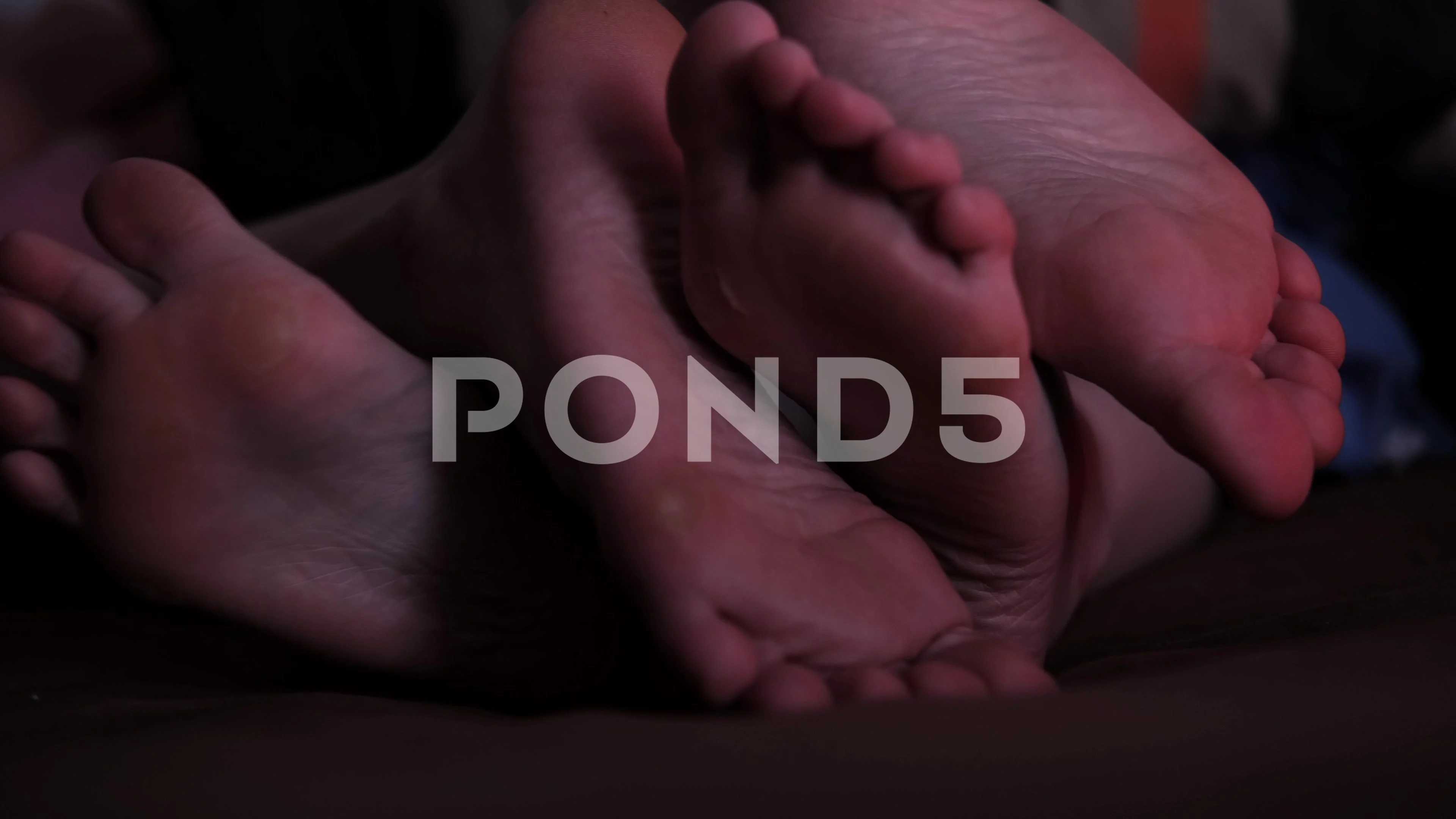 Two pairs of female feet in bed stroking... | Stock Video | Pond5