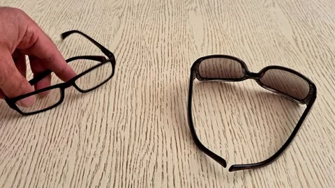 Two pairs of glasses lying on a light wooden table surface 動画素材 337218516