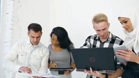 Two pairs of purposeful men and multiethnic women working together with Stock Footage 121841044
