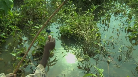 TWO PAKRO BOYS PREPPING HANDMADE FISHING POLE Stock Footage 58930524