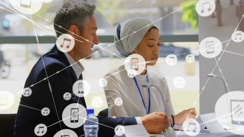 Two panelists writing notes at meeting, animated icons growing from central node Stock Footage 332981372
