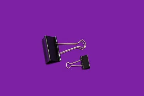 Two paper clips on a purple background Stock Photos