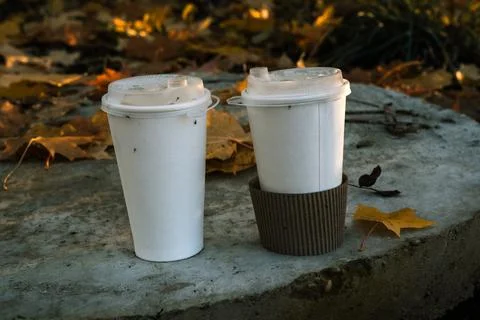 Two paper coffee cups stand on a concrete slab. Minimalism coffee cups Stock Photos