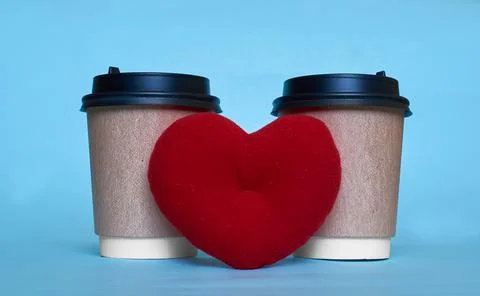 Two paper cups for coffee and a toy heart. Space for text Stock Photos