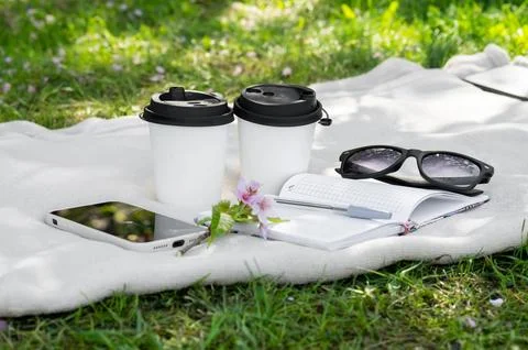 Two paper cups of coffee or tea and a sakura branch on a light blanket, a not Fotos de archivo