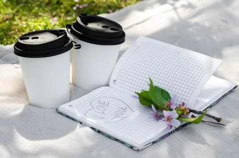 Two paper cups of coffee or tea and a sakura branch on a light blanket, a not Stock Photos