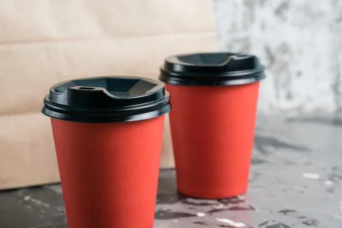 Two paper cups for tea or coffee to go and takeaway craft bag on gray backgro Stock Photos