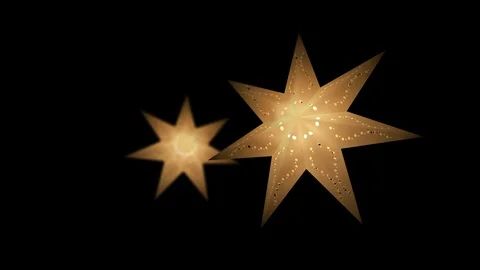 Two paper star lanterns shining and glowing with warm light in yellow color Video stock 98535440