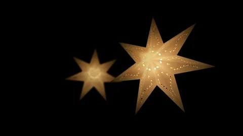 Two paper star lanterns shining and glowing with warm light in yellow color Stock Footage