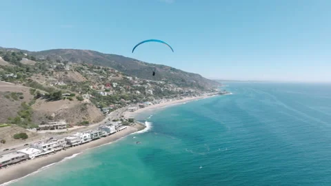 Two paragliders fly from mountains above epic Malibu ocean coast, paragliding 4K Vídeo Stock 217408514