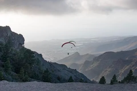 Two paragliders flying between mountains ridges in Tenerife Foto stock