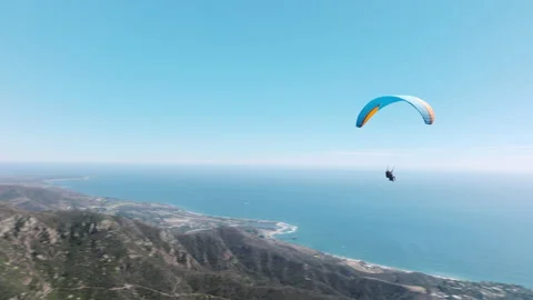 Two paragliders flying over mountain top in epic summer day light, Parachute 4K Stock Footage 215053301