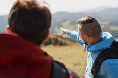 Two paragliders men standing on the top of mountain, looking at view and Stock Photos