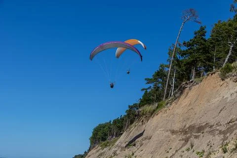 Two paragliders next to a sloping cliff Stock Photos