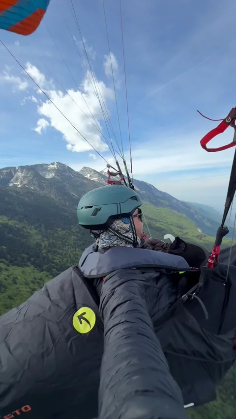 Two Paragliders Soar Above Misty Mountain Ridges Beneath a Clear Sky, Creating Stock Footage 337405894