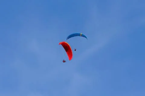 Two Paragliders Soaring in Clear Blue Sky Stockfoto's