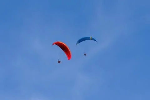 Two Paragliders Soaring in Clear Blue Sky Stockfoto's