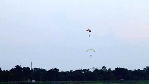 Two Paragliders Soaring Over Rural Landscape at Dusk Stock Footage 311586501