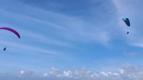 Two Paragliders Soaring Through a Bright Blue Sky with Clouds Vídeos de archivo 334590482