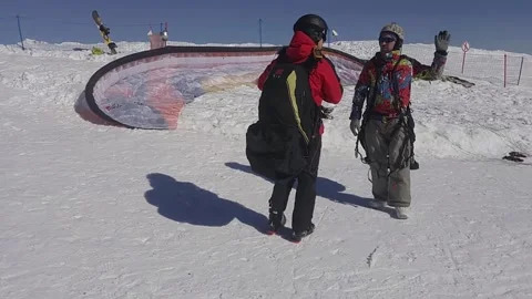 Two paragliders talk and prepare paraplane on Stock Footage 299617780