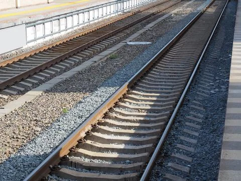 Two parallel railways illuminated by the sun's rays are narrowing in perspective 库存照片
