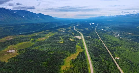 Two parallel roads crossing the huge green valley among the mountains. Video stock 321021018