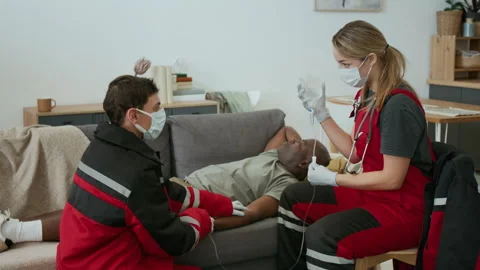 Two Paramedics Providing IV Therapy to Patient at Home 스톡 동영상 293668795
