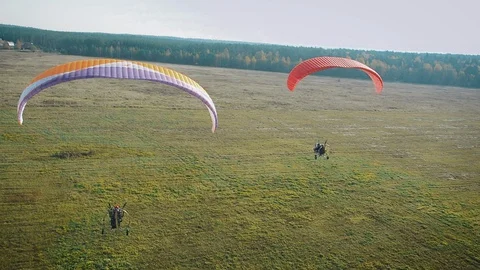 Two paratrikes fly over the countryside. Stock Footage 129546596
