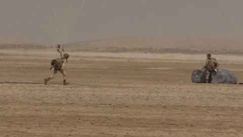 Two Paratrooper in the Middle of a Desert Stock Footage 128553101