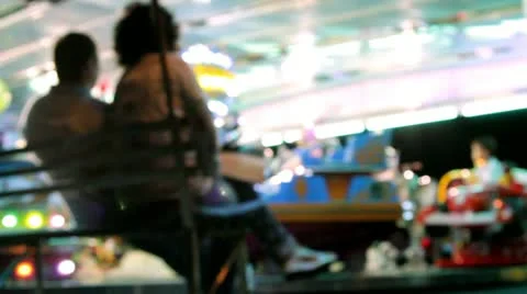 Two parents watching son has fun on the carousel. Blurred, out of focus. Stock-Footage 12125746