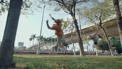 Two Parkour Athletes Performing Side Flips in the Park Stock-Footage 242102079