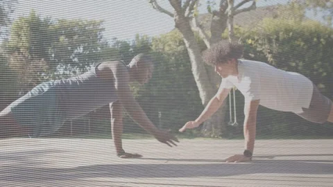 Two partners placing hands on deck, performing synced push-ups, clasping one-arm 스톡 동영상 332897484