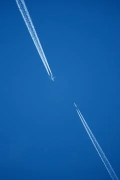 Two Passenger Airplanes Flying in Parallel with Contrails Stock Photos