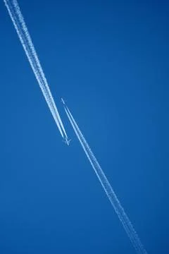 Two Passenger Airplanes Flying in Parallel with Contrails Stock Photos