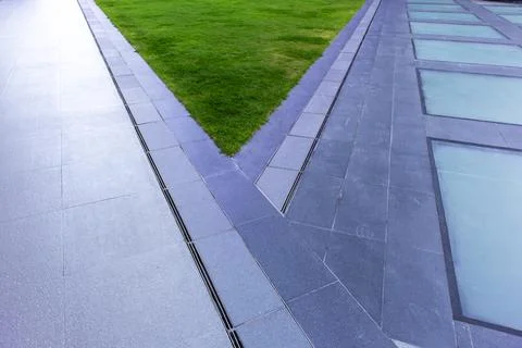 The two paths separate, with a grassy area in the middle of the park. Stock Photos