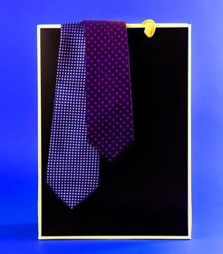 Two patterned neckties hanging from a gift bag Stock Photos