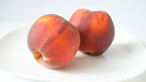 Two peaches rotate on white background Stock Footage 94469058