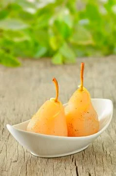 Two pears poached in syrup Stock Photos