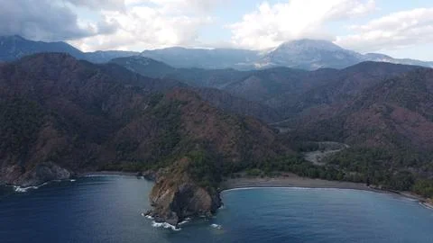 Two pebble beaches separated by a mountain with a mountain road with mountains Foto stock