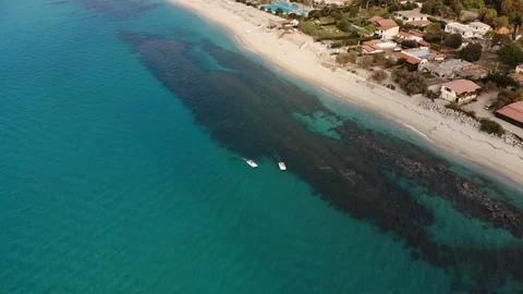 Two pedal boats float on clear turquoise sea waters by sandy beach of Italian 스톡 동영상 102457088