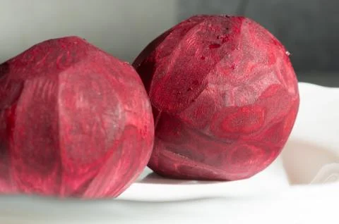 Two peeled beets that lying on the white plate. Stock Photos